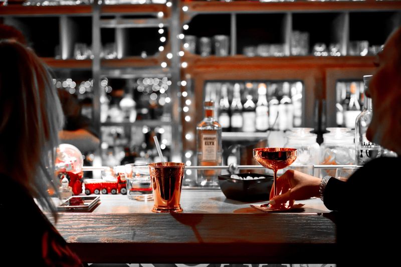 Cocktails being raised at a softly lit bar